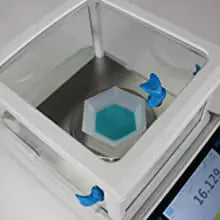 Device on lab bench with draft shield visible of Kern high-accuracy weighing device