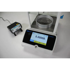 Device on lab bench with draft shield visible of Kern high-accuracy weighing device